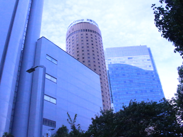 背の高い茶色い円柱型のビルが特徴的な大阪マルビル